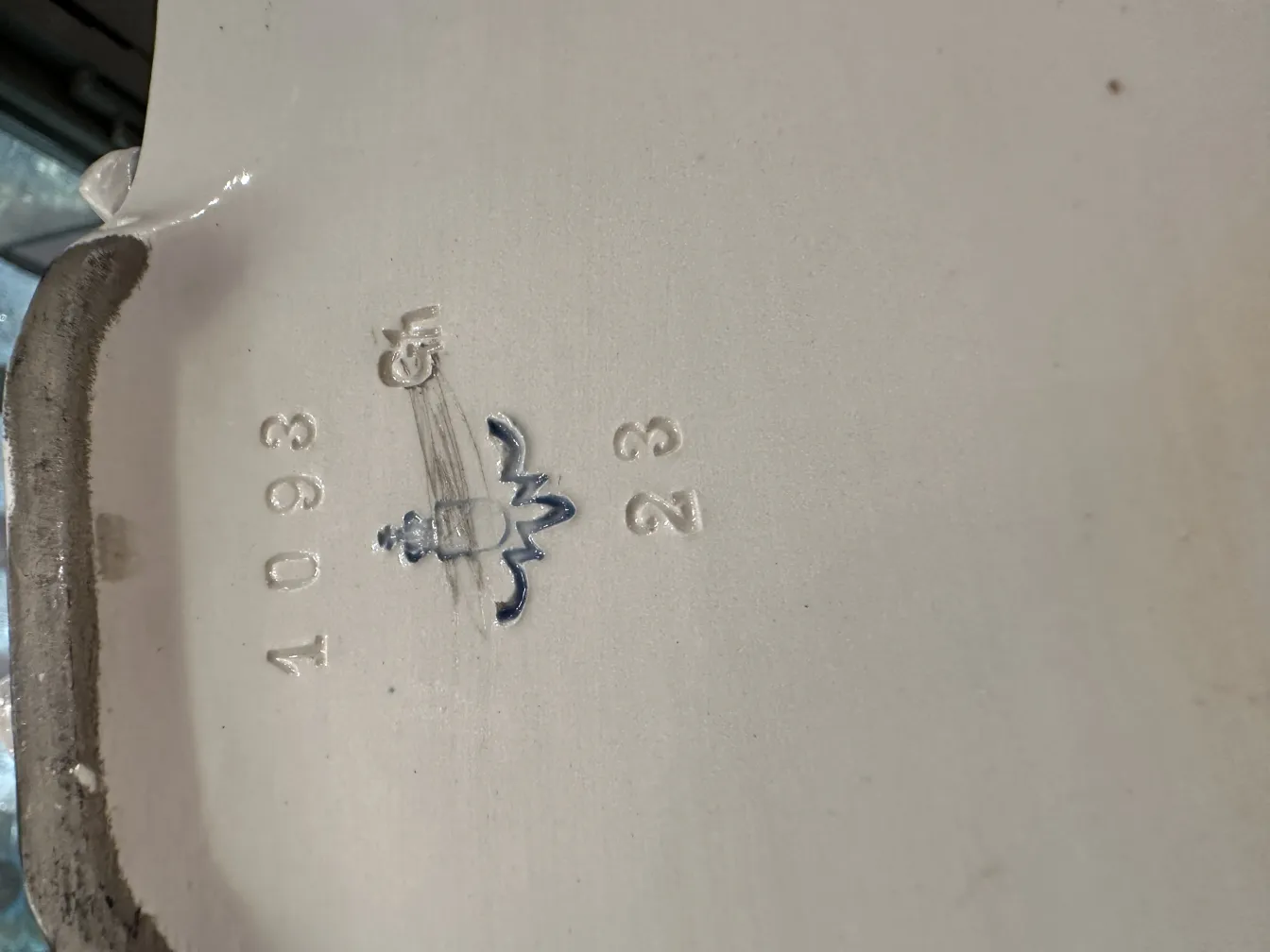 Antiga cerâmica decorativa com detalhes em azul e branco, ambiente vintage.