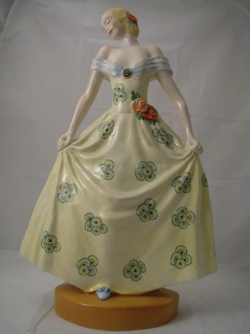 Figura decorativa em cerâmica com vestido amarelo e flores