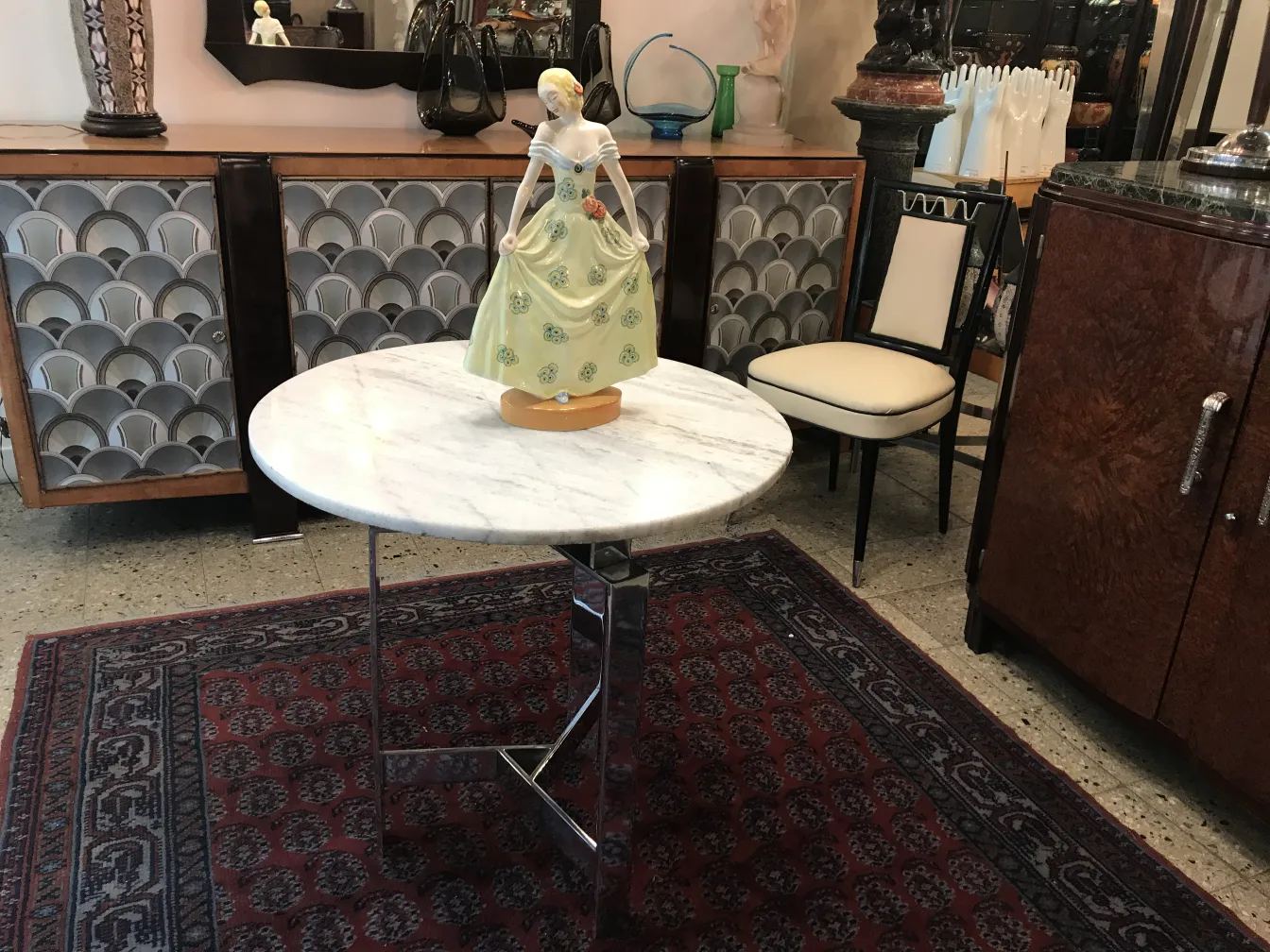 Figura decorativa de cerámica antigua con vestido colorido en mesa.