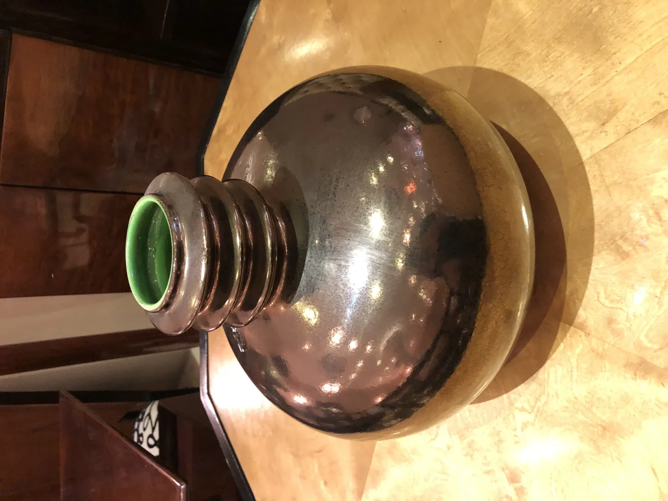 سيراميك-قديم-بتشطيب-لامع-وتفاصيل-خضراء-على-الحافة،-على-طاولة-خشبية.