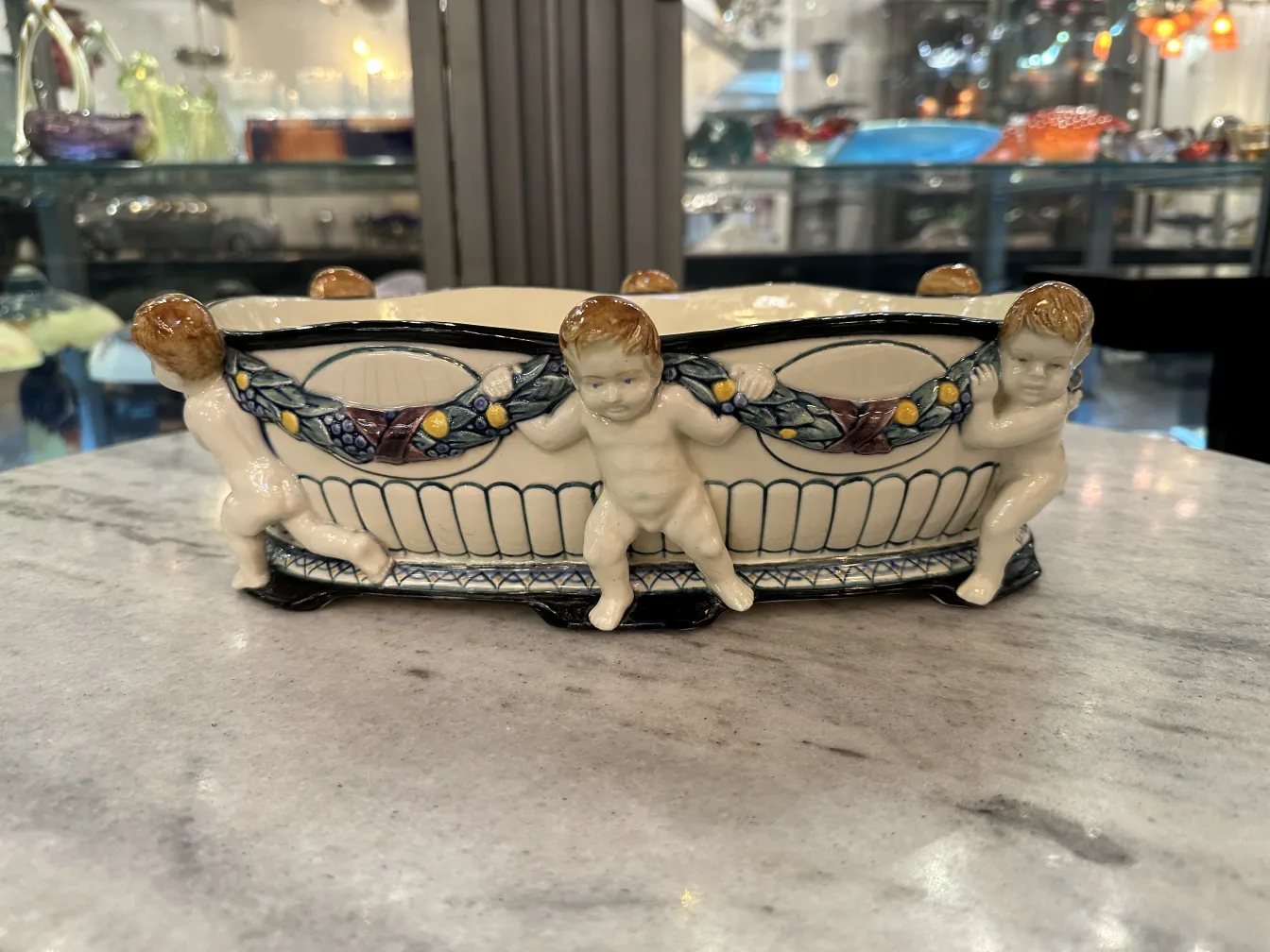 子供の浮彫りとカラフルなデザインの古い陶器。