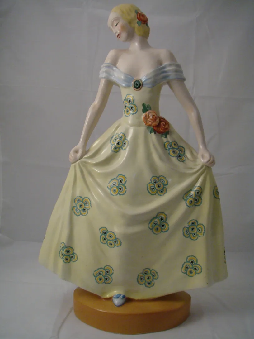 figurina in ceramica antica di donna con vestito giallo e fiori