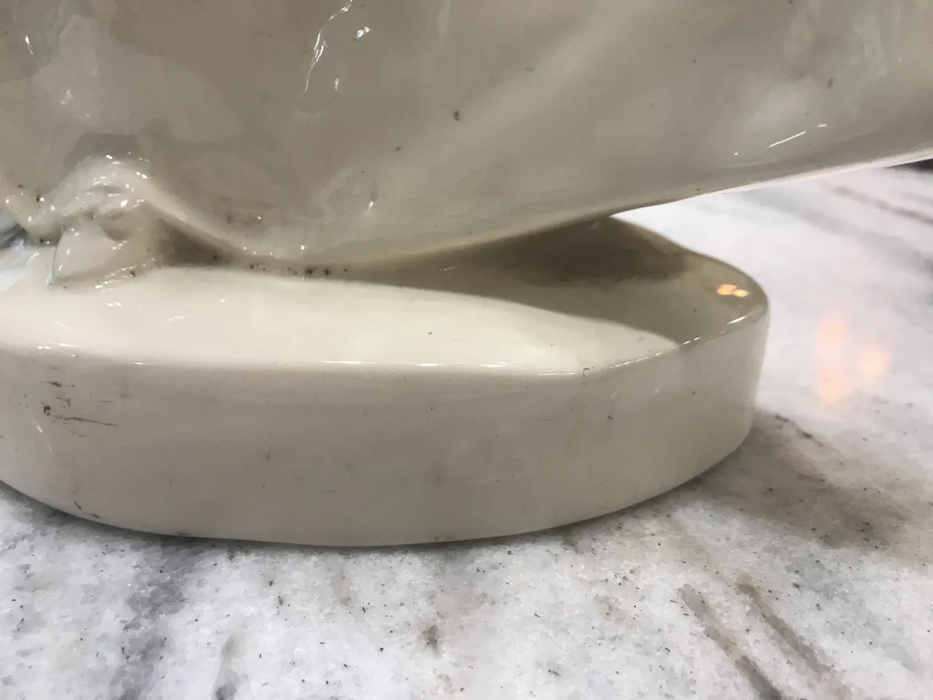 Antica ceramica con smalto bianco e finitura lucida, base arrotondata.