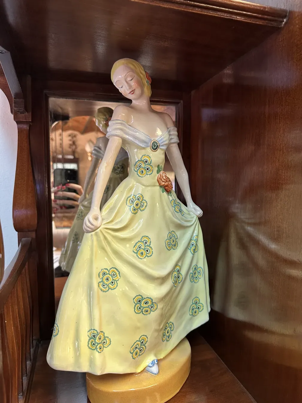 Figura de cerâmica antiga Boch em vestido amarelo com flores.