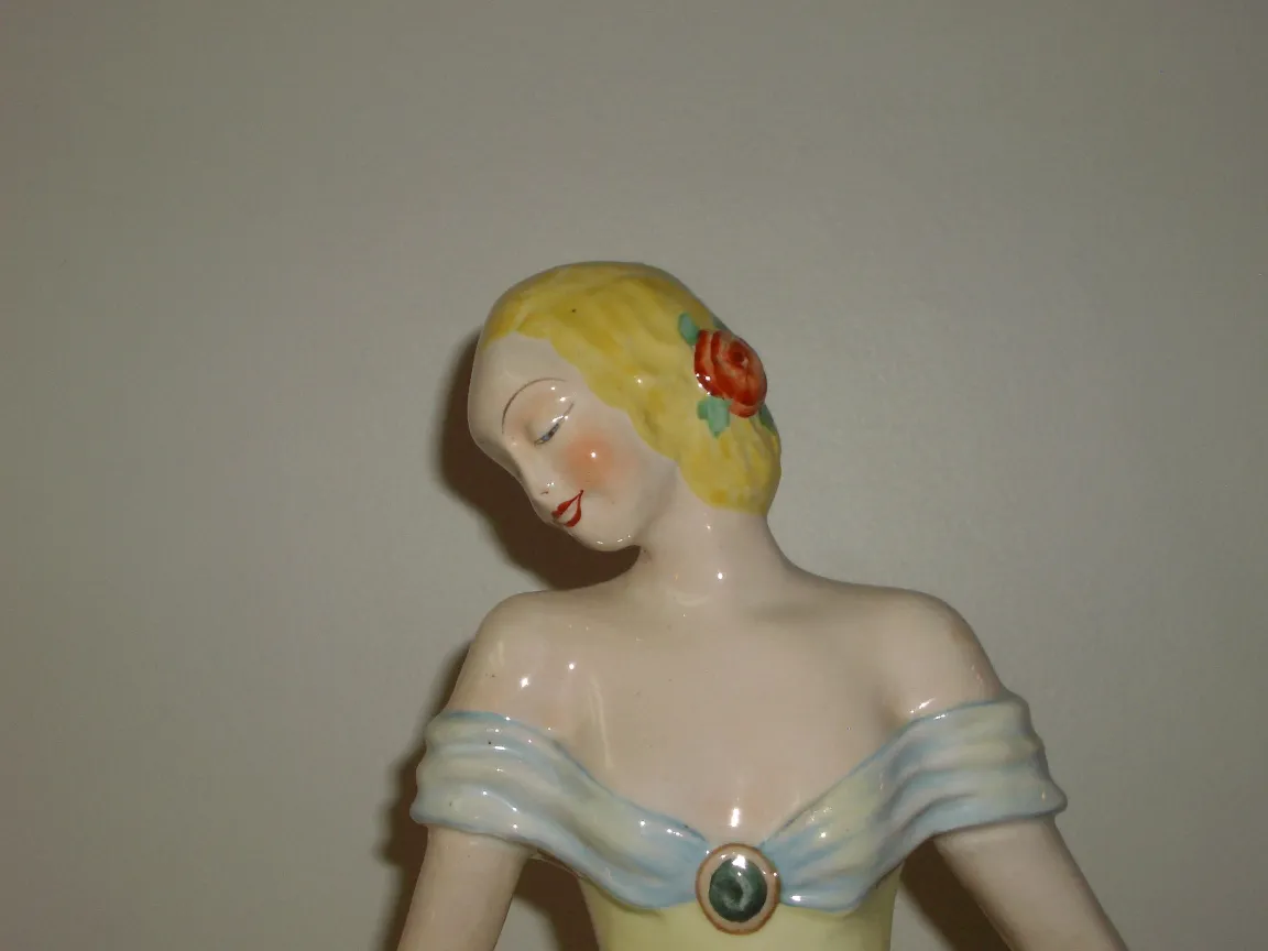 Antike Keramikfigur mit bunten Details und zarten Zügen.