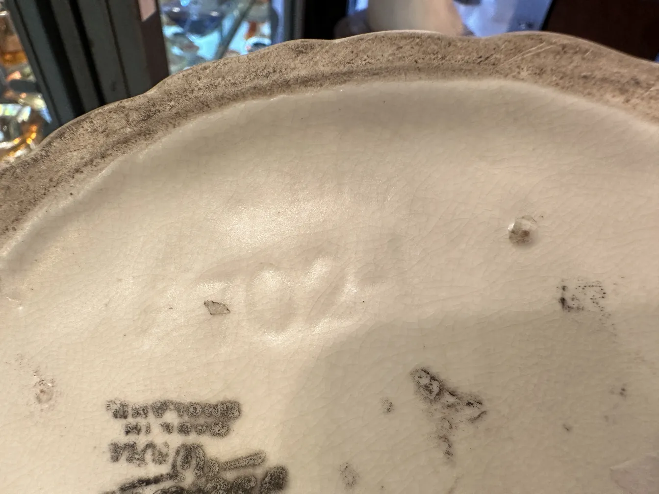 View of the bottom of an antique ceramic with visible marks