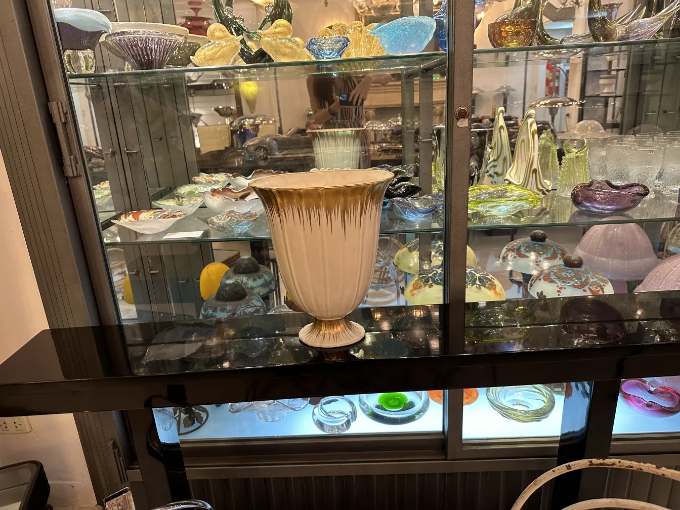 古董陶瓷花瓶，独特的细节和优雅的设计，展示在一个柜子里，与其他装饰物品。