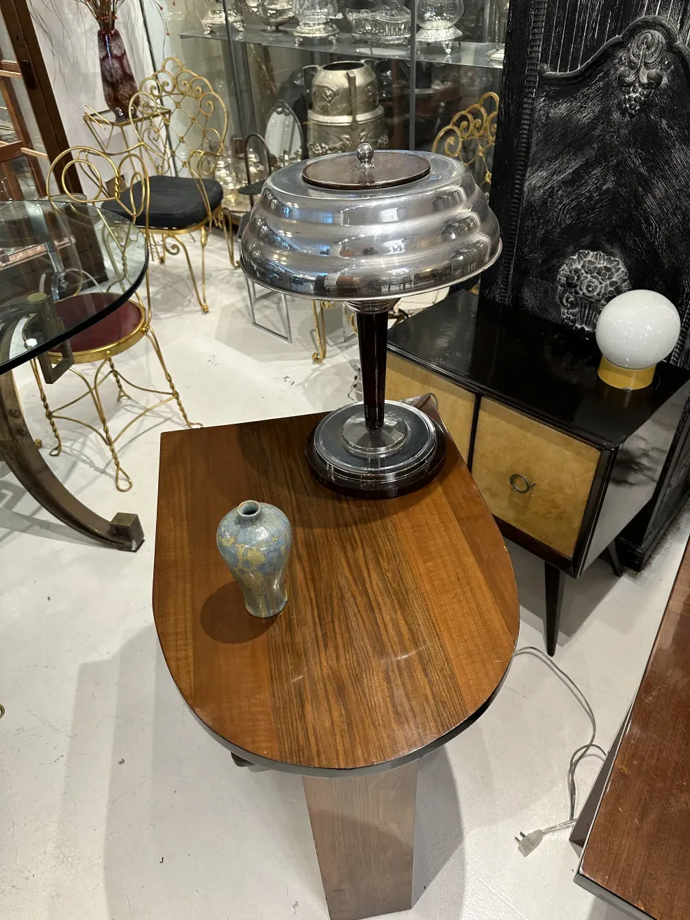 Small antique ceramic on wooden table with lamp and gold chairs