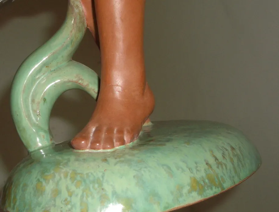 Antique ceramic sculpture featuring green and terracotta details.