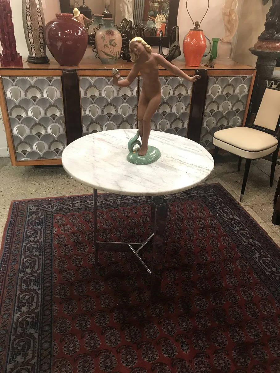 Round white table with ceramic figure of a naked woman