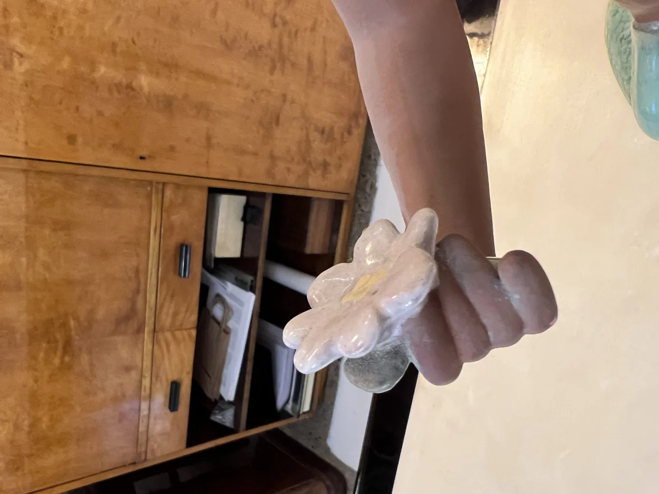 cerámica antigua en forma de flor, colores suaves, fondo natural