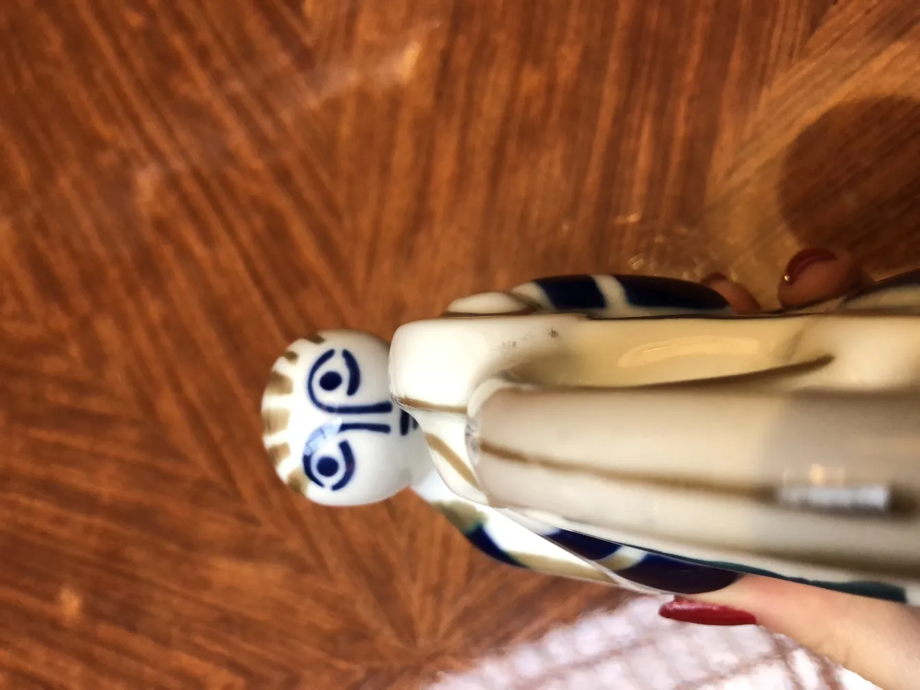 figura cerámica antigua con detalles azules y blancos