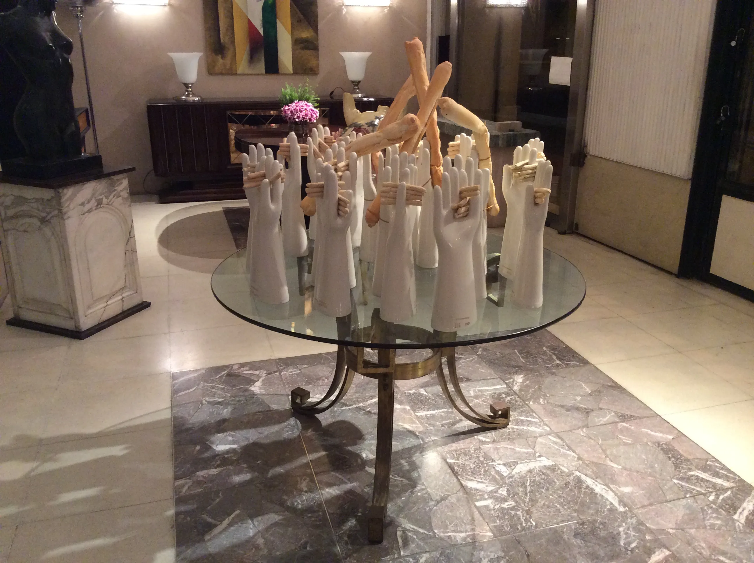 Tavolo da pranzo antico per 4 persone con design Art Deco, decorato con mani scolpite, in un ambiente elegante.