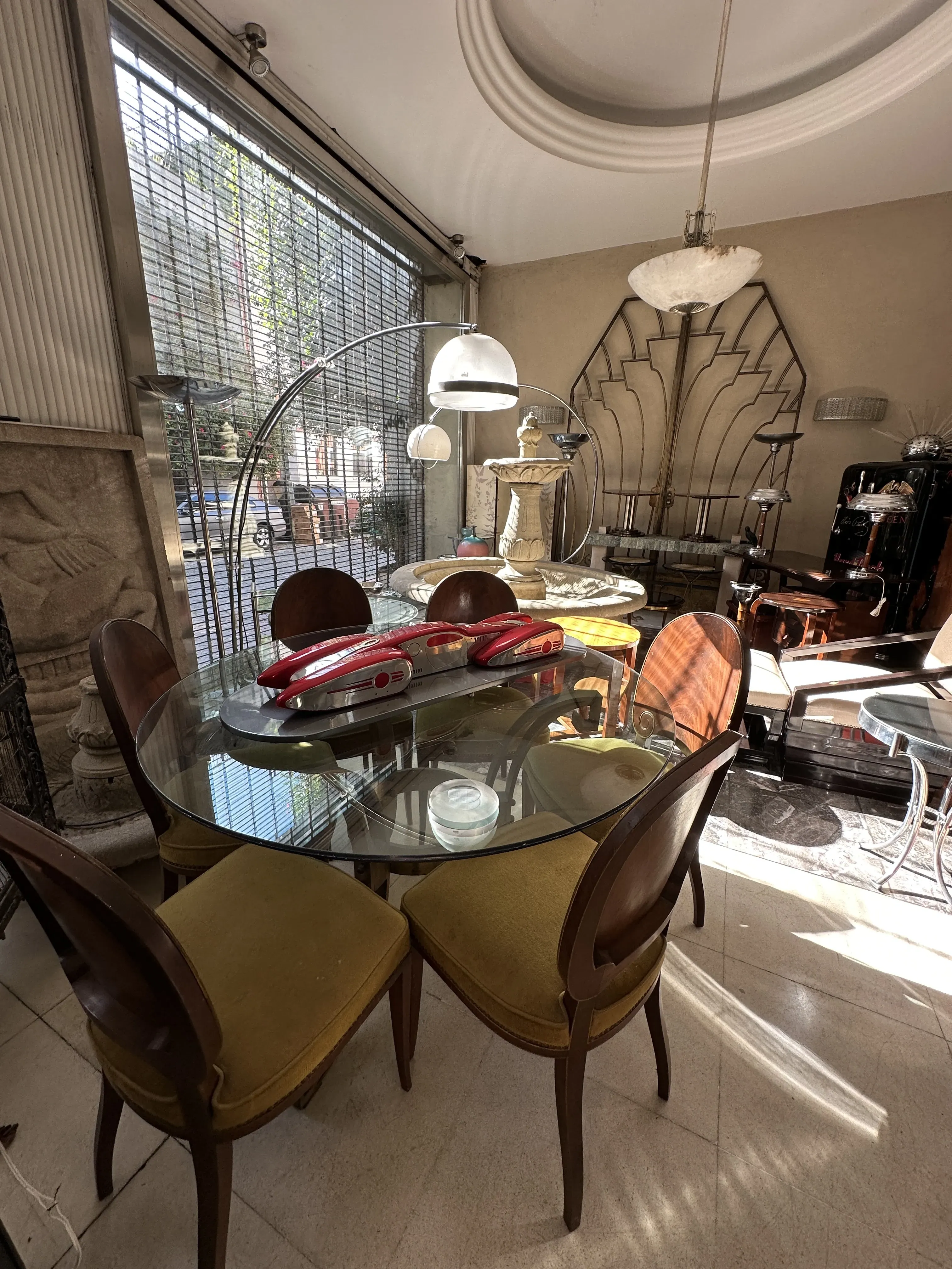 Antique dining table with yellow chairs in Art Deco setting.