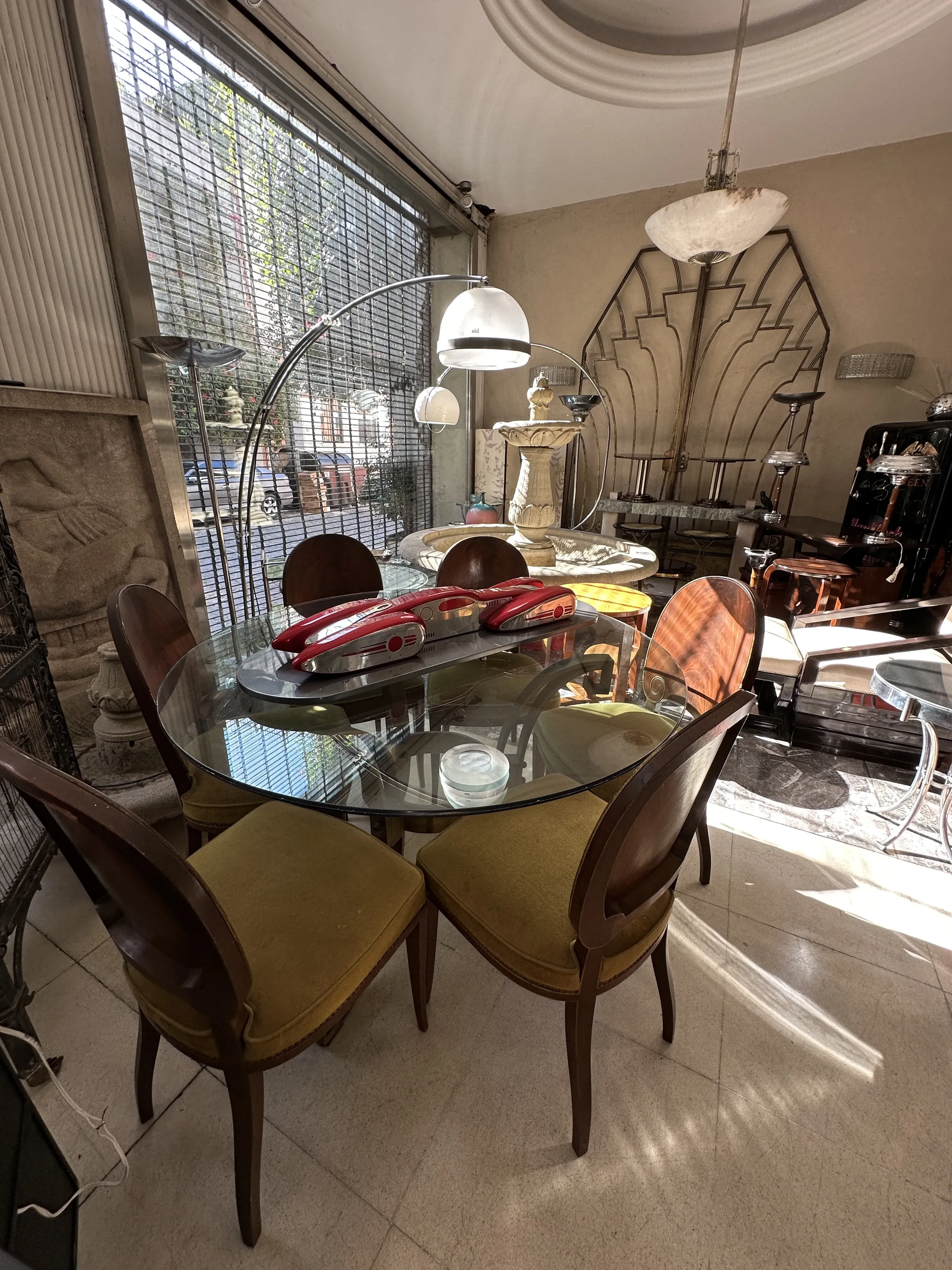 Mesa antiga de jantar cercada por cadeiras em um ambiente bem iluminado