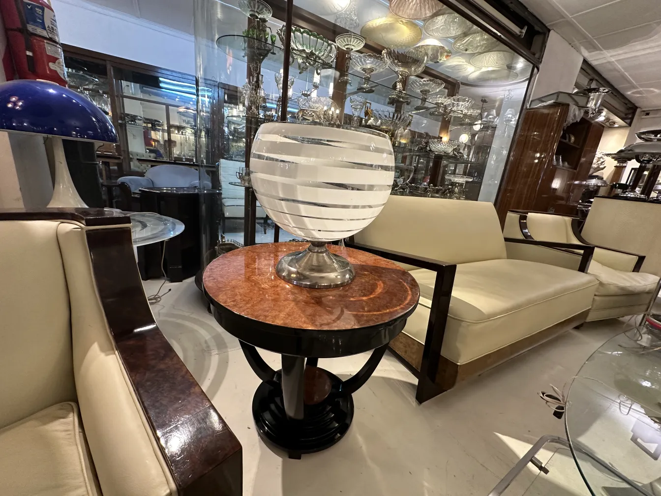 Luminária de mesa antiga com base prateada decorativa, em um ambiente de antiguidades.