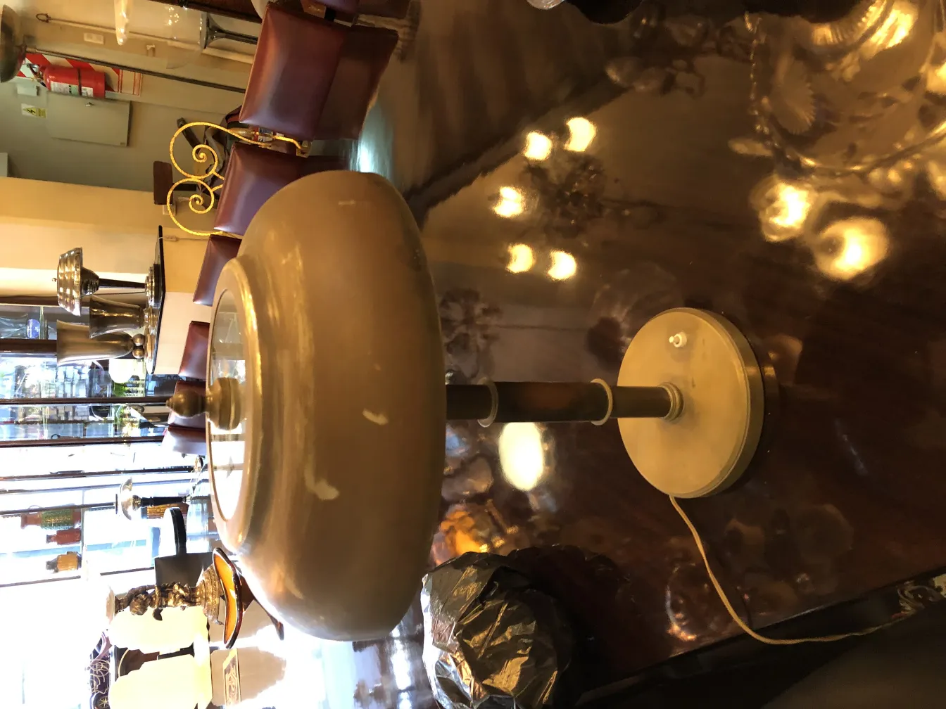 Vintage table lamp with curved base and soft light, complemented by leather chairs.