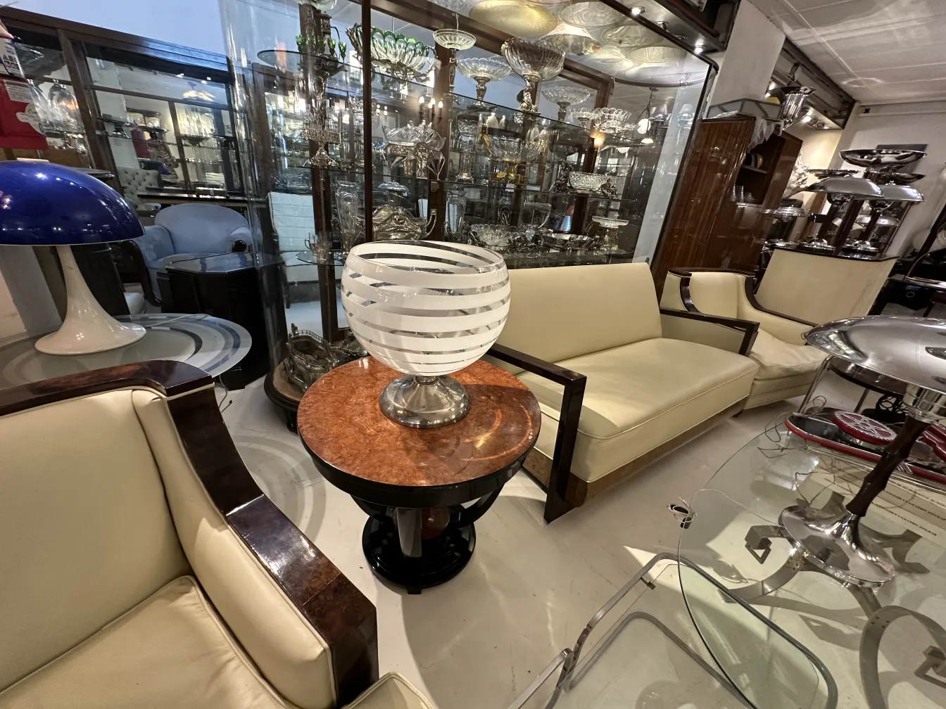 Antique table lamp with circular design and silver base in an antique setting.