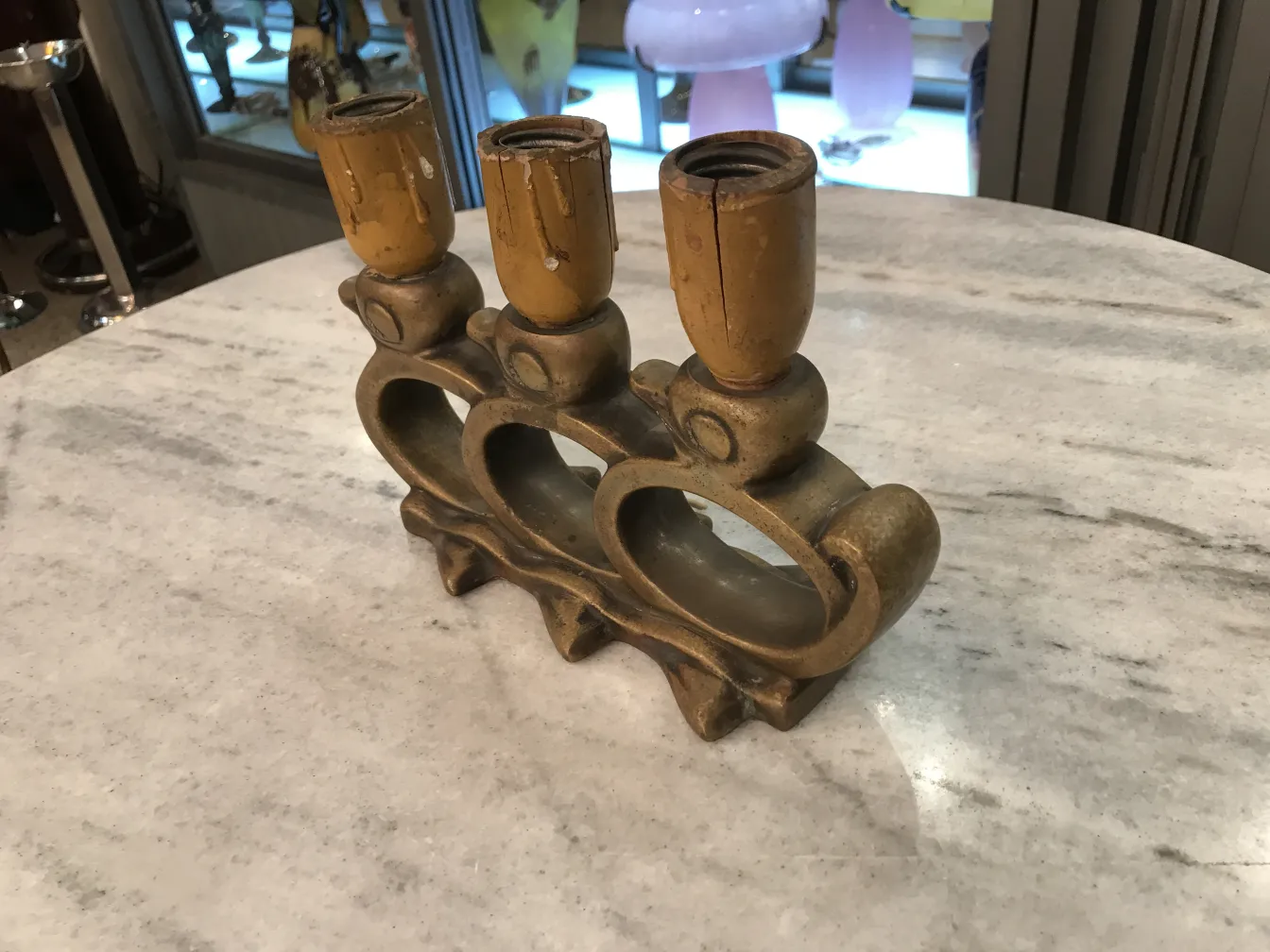 Luminária de mesa antiga com três bases de suporte em uma mesa