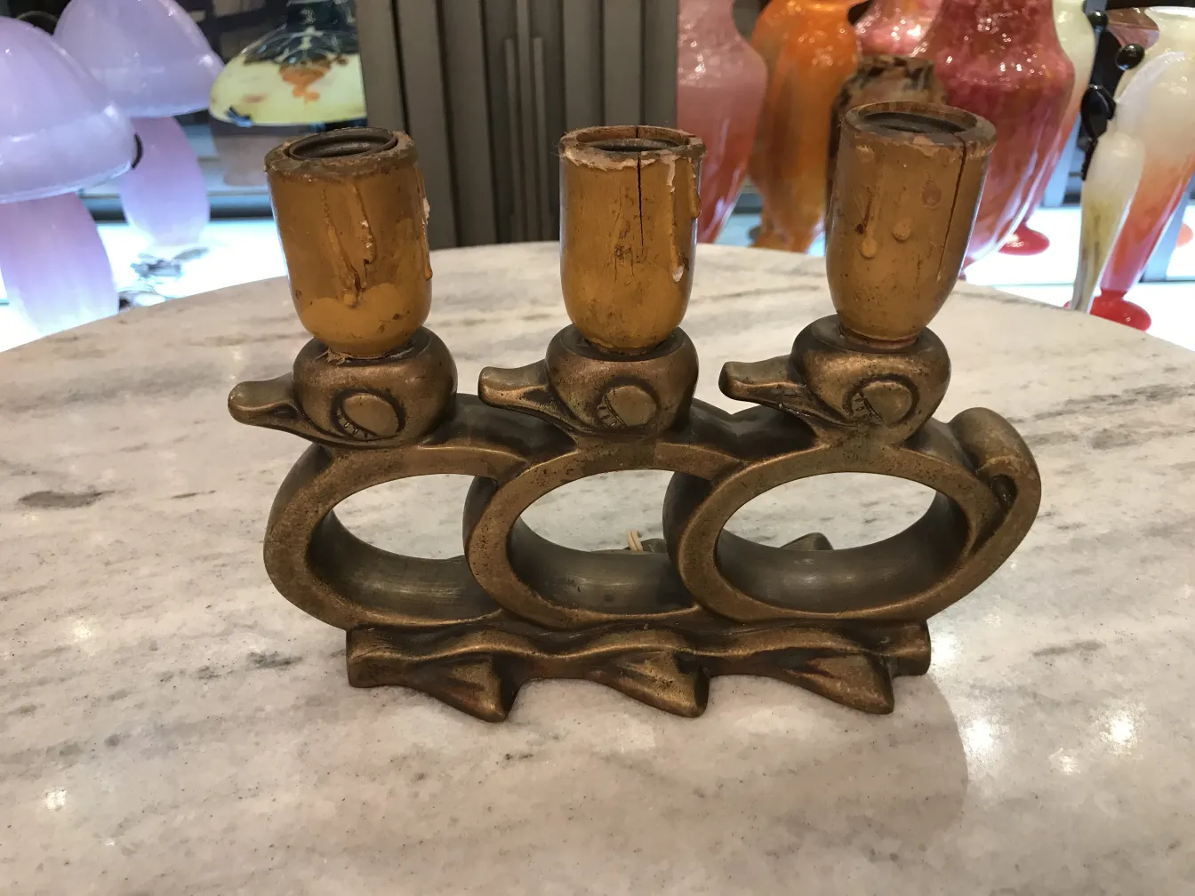 Ancienne lampe de bureau à trois bras, design artistique et ambiance chaleureuse.