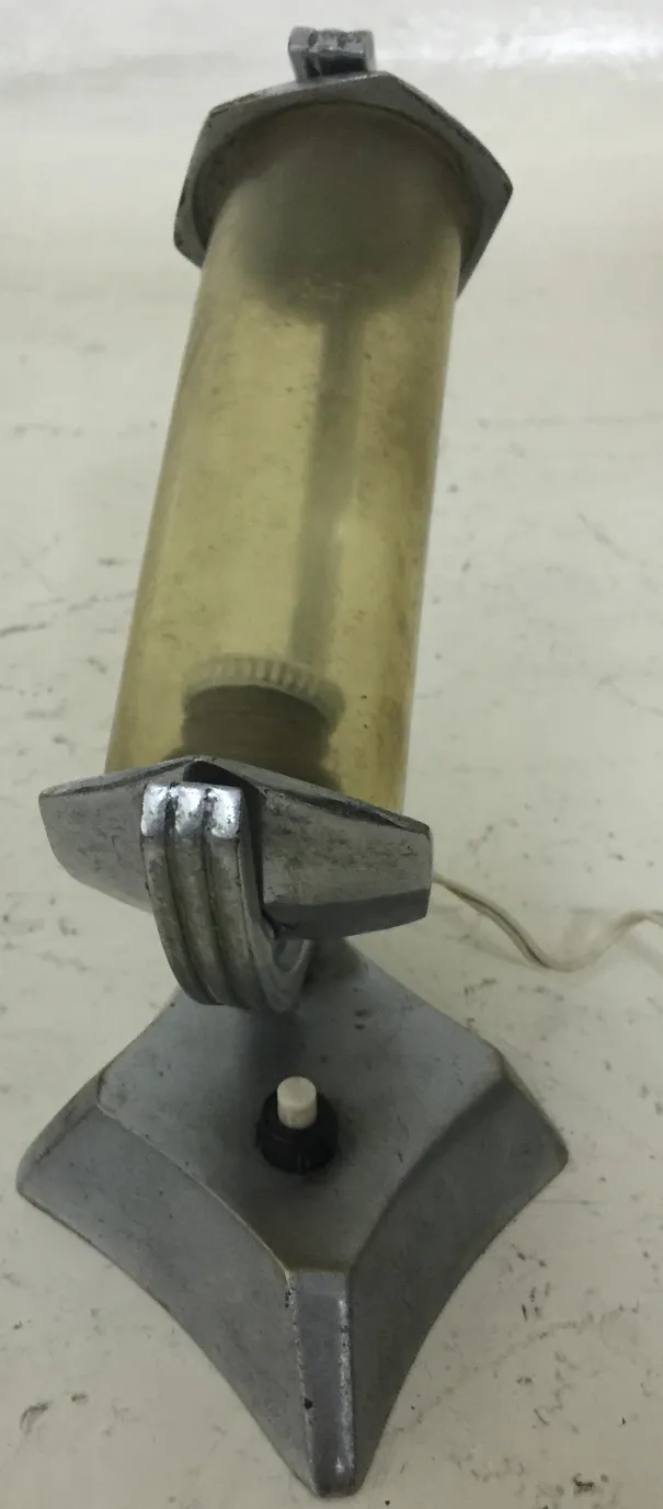 antike Tischlampe mit zylindrischer Form und dekorativem Sockel, in einer gemütlichen Umgebung