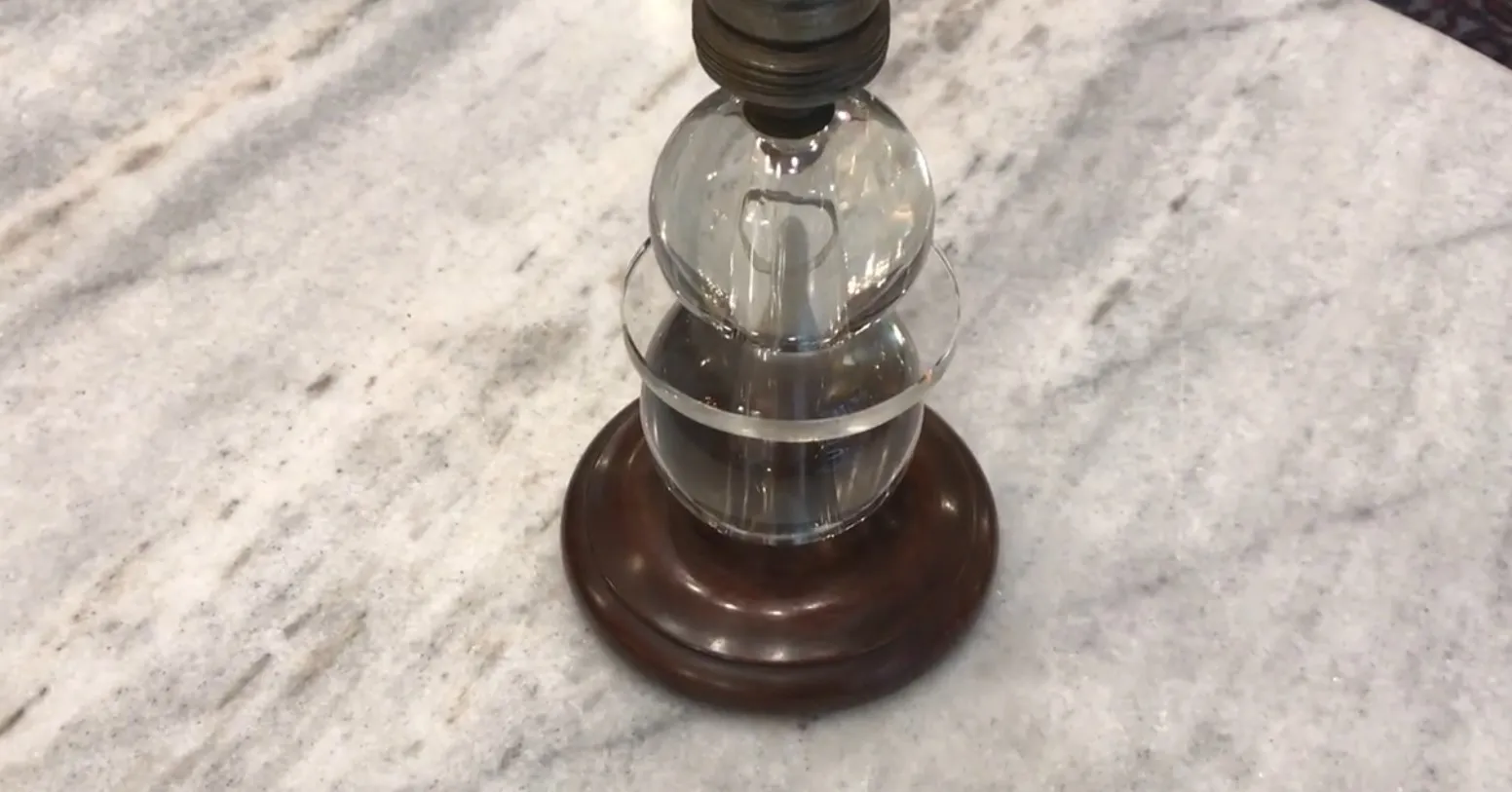 Antique table lamp with round base and elegant design.