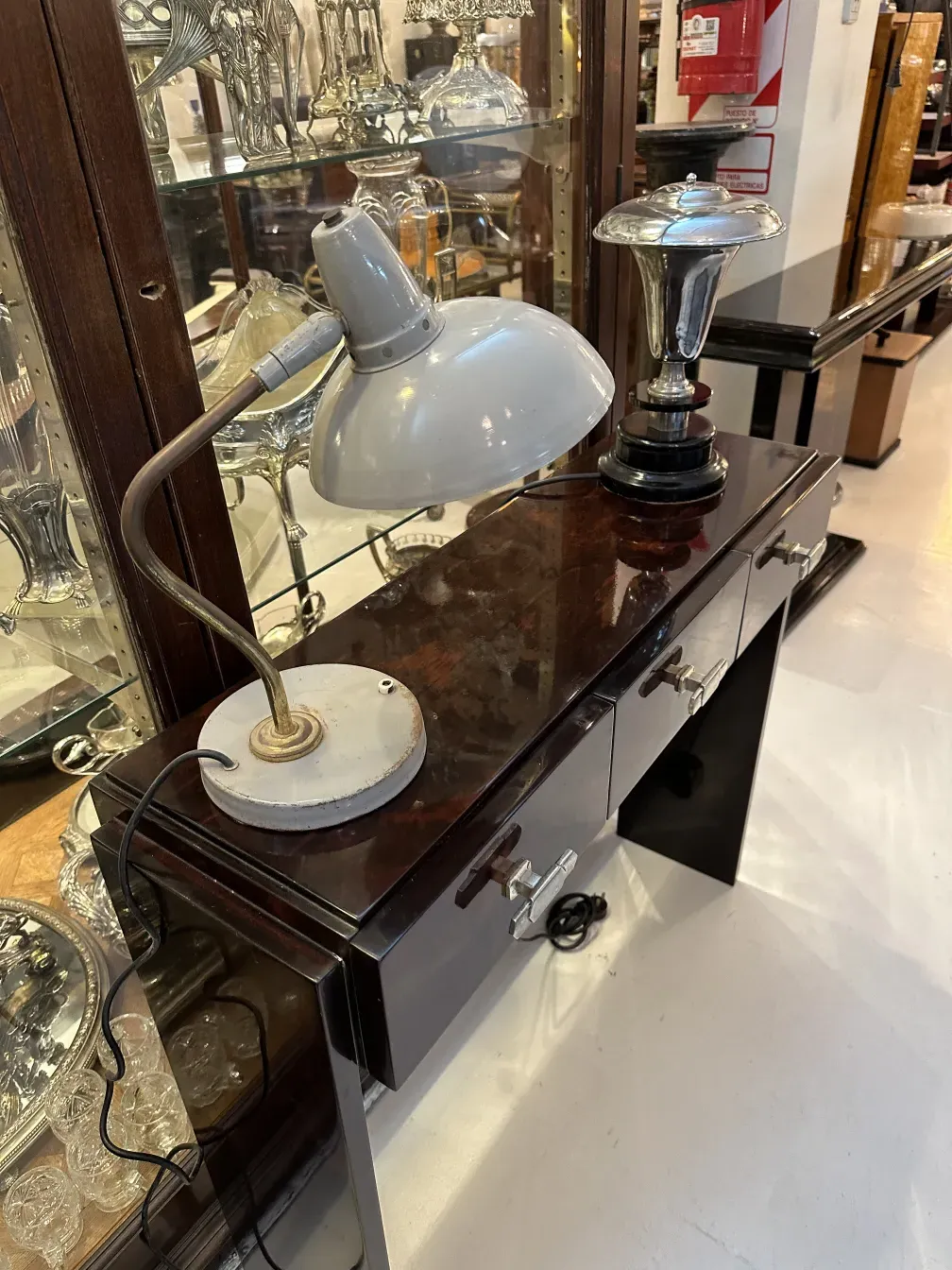 Antica lampada da tavolo di Serge Mouille, design elegante con base nera, posizionata su un tavolo di legno.