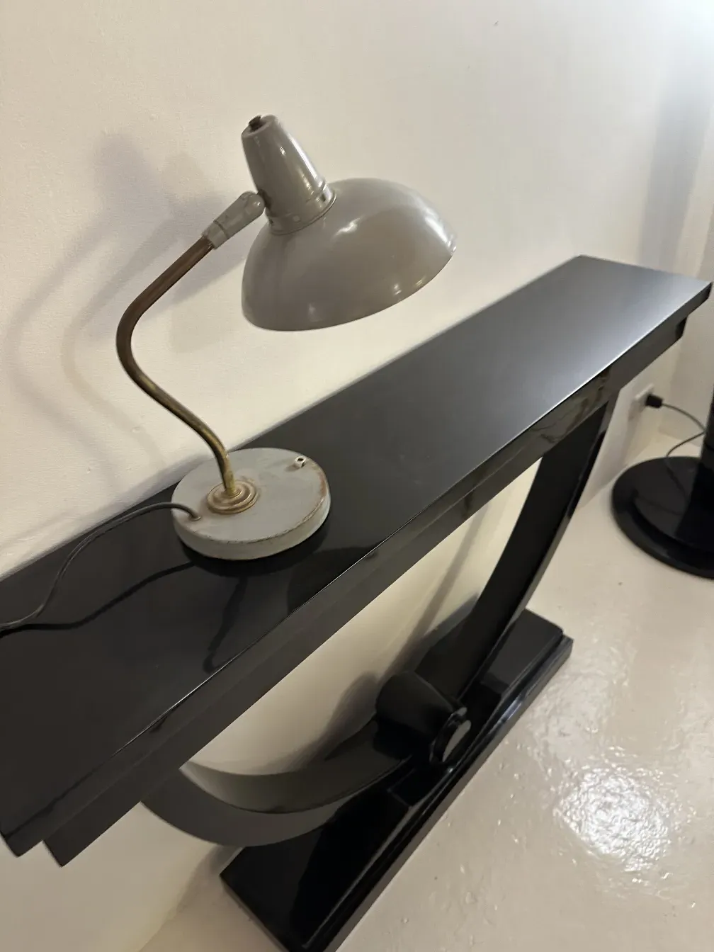 antique table lamp by serge mouille on a black table