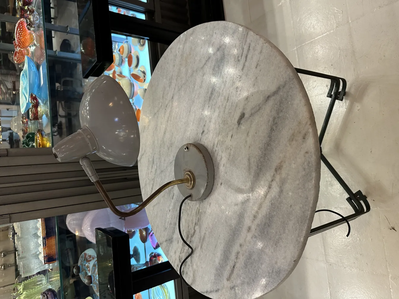 lampara de mesa antigua con diseño elegante y base redonda, rodeada de objetos decorativos