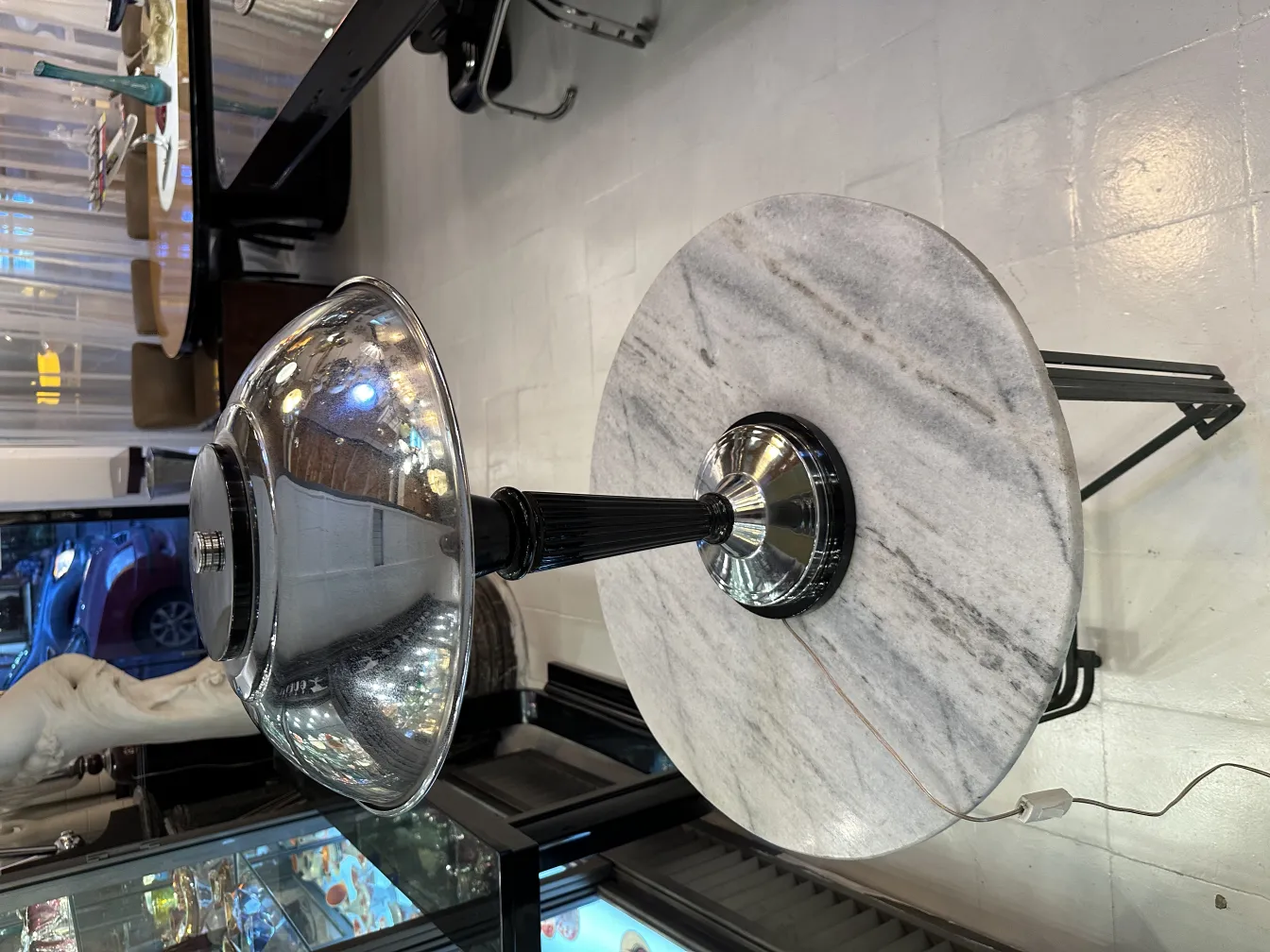 Antike Tischlampe mit glänzender Basis und rundem Schirm in einem eleganten Ambiente.