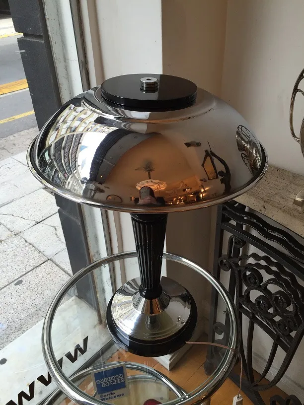 ancienne lampe de bureau avec un abat-jour en métal réfléchissant et des détails polis, dans un cadre accueillant.