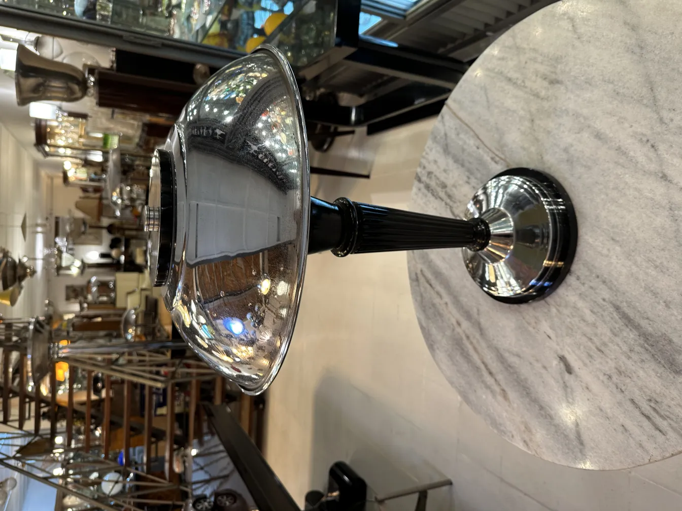 Luminária de mesa antiga com acabamento brilhante, ambiente acolhedor.