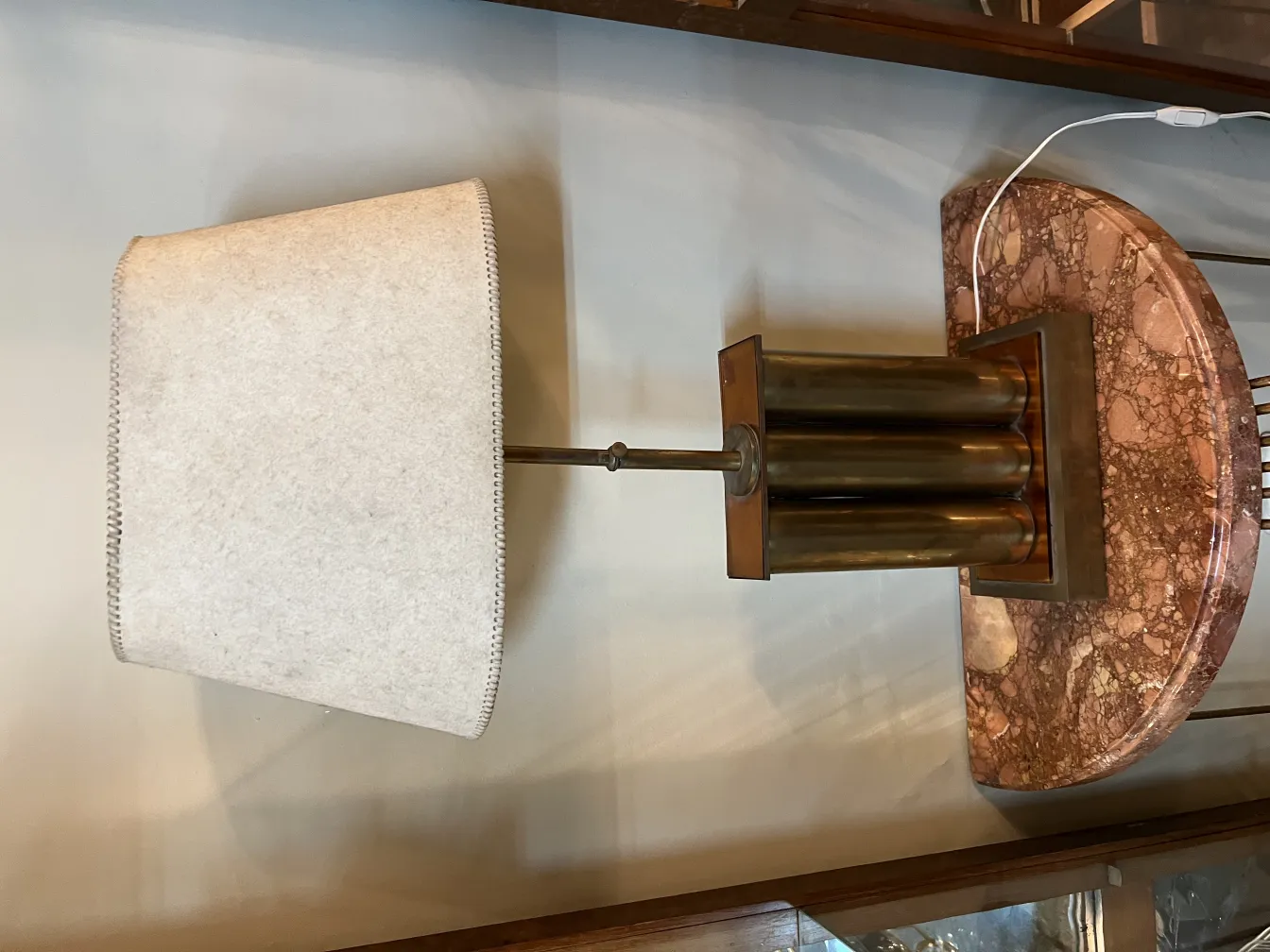 Lampe de bureau ancienne avec abat-jour clair dans un environnement chaleureux.