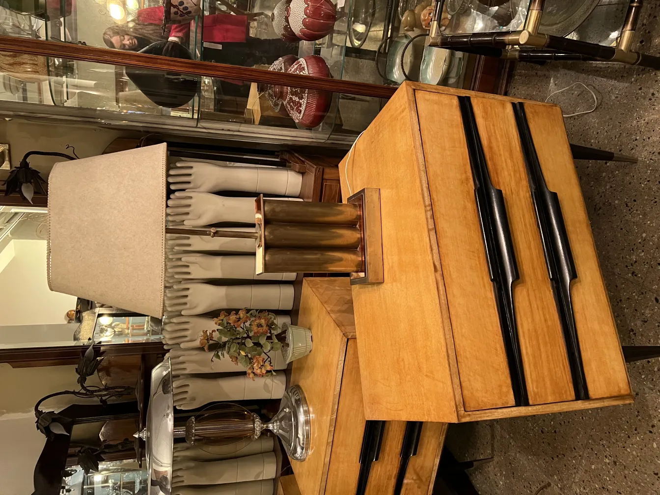 Lampada da tavolo antica con un elegante paralume e elementi decorativi sullo sfondo.