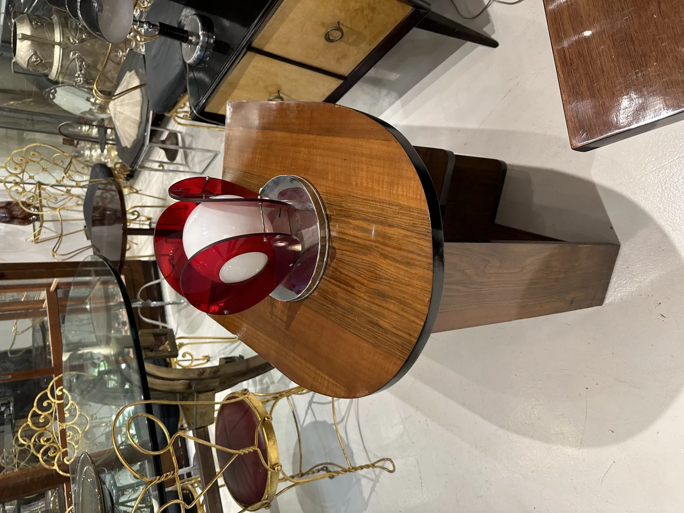 luminária de mesa antiga com base vermelho e forma redonda, em um ambiente elegante