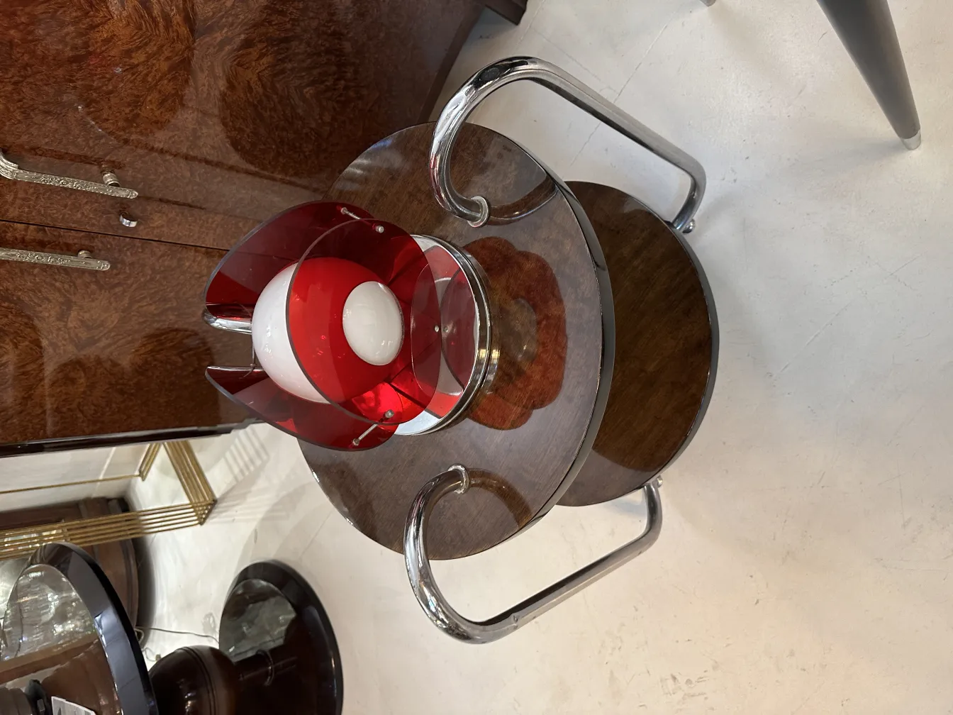 Luminária de mesa antiga com detalhes em vermelho sobre uma mesa