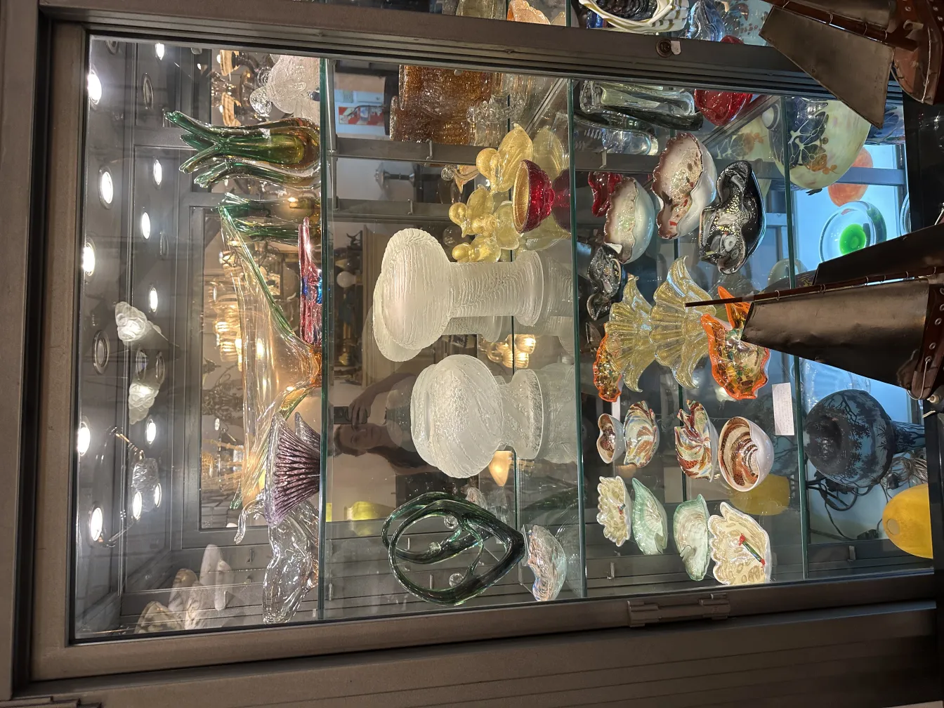 lampara de mesa antigua en vitrina con decoraciones coloridas