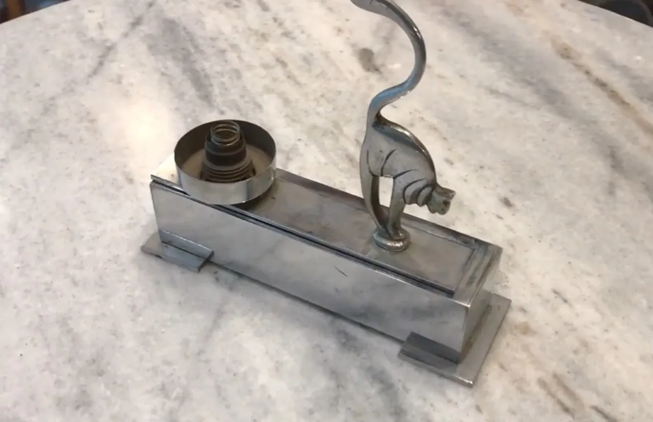 lámpara de mesa antigua con diseño de gato sobre mesa de mármol