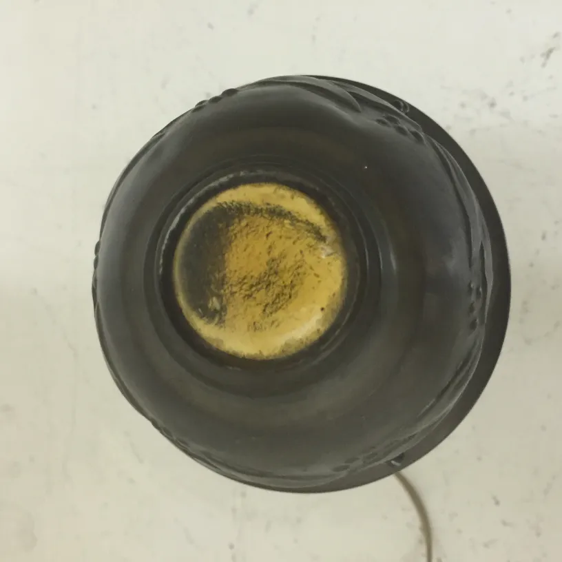 पुरानी टेबल लैंप का ऊपरी दृश्य, जो क्लासिक सेटिंग में है।