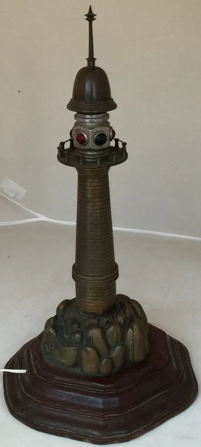 lampara de mesa con base de roca y diseño de faro antiguo