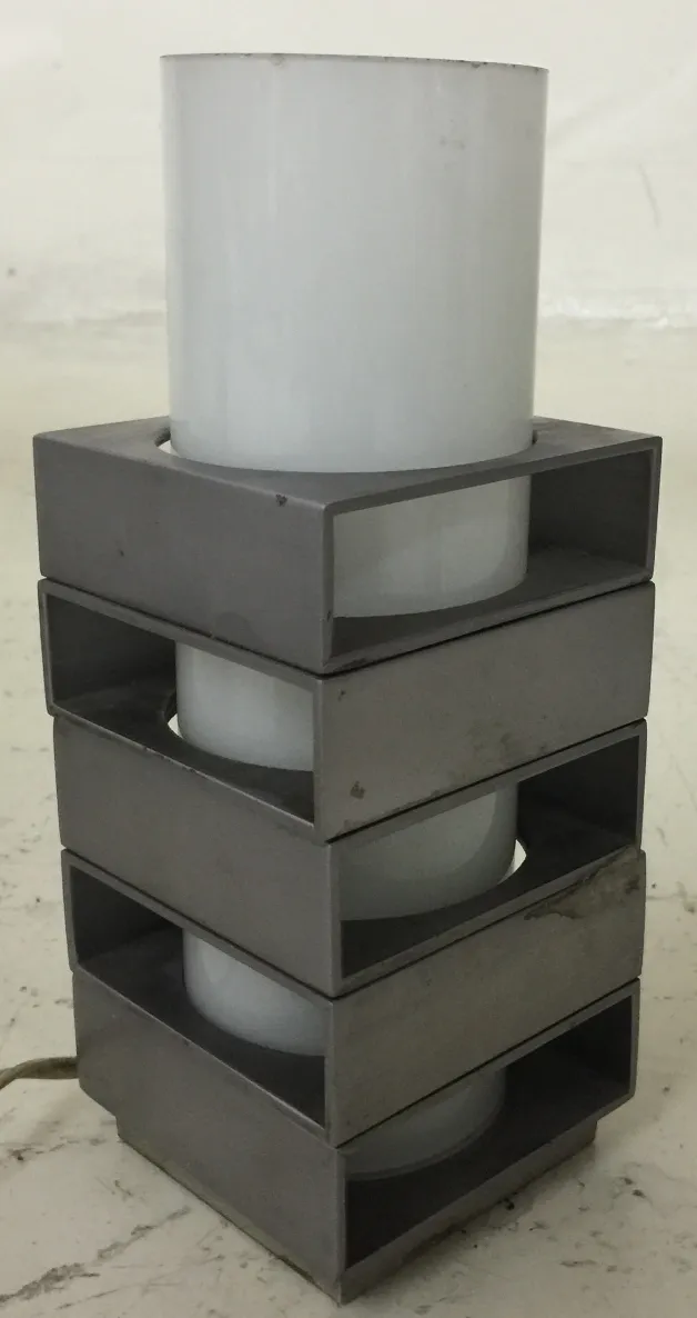 Lámpara de mesa antigua de diseño geométrico, en un entorno minimalista.