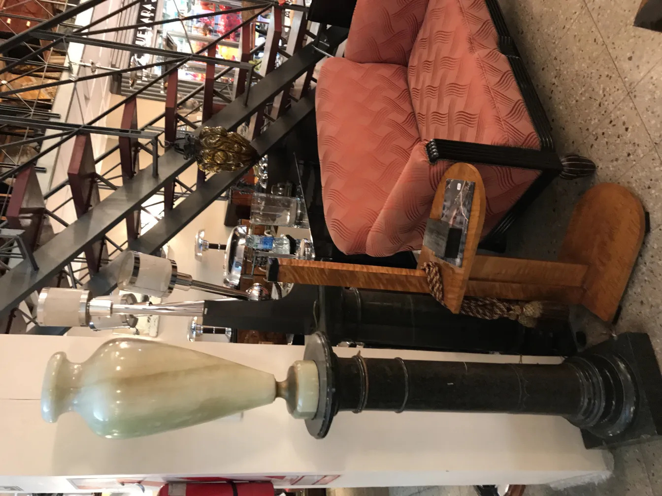 Antique table lamp with a unique and elegant design, accompanied by a striking pink sofa.