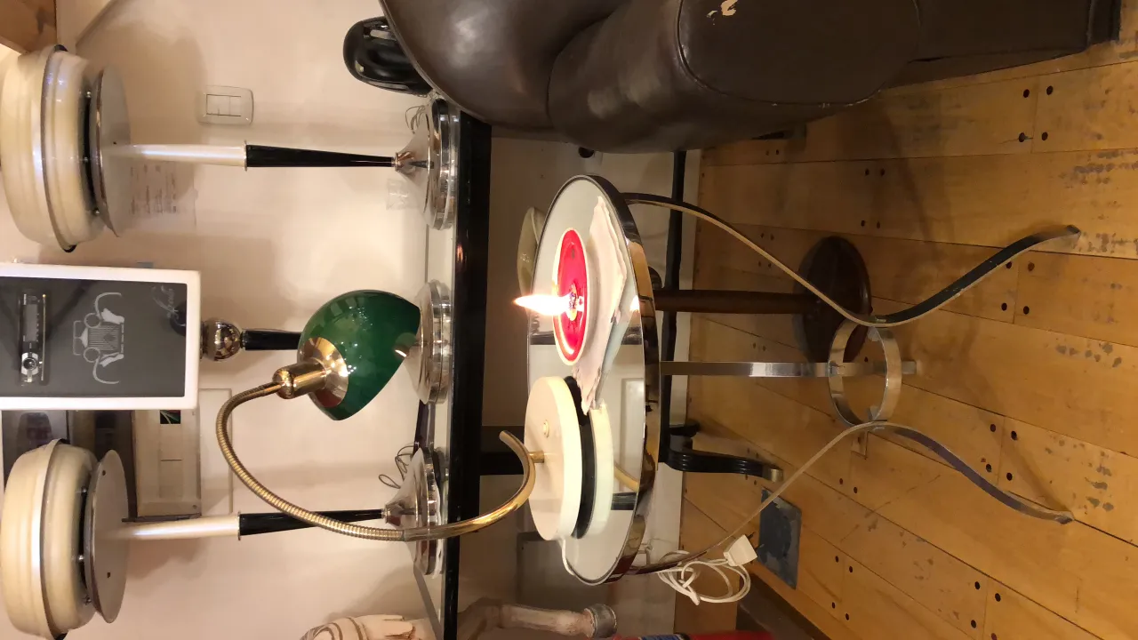 Lampada da tavolo antica con base dorata e paralume verde in un ambiente elegante