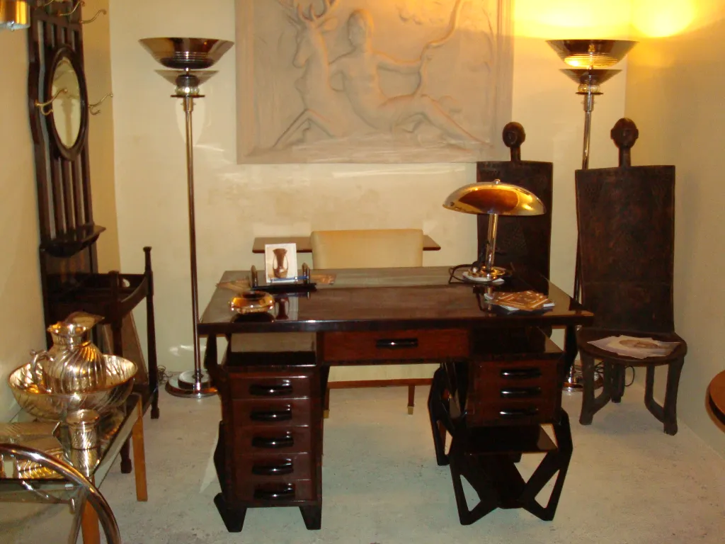 Antica lampada da tavolo con design classico in un ambiente elegante, circondata da mobili antichi.