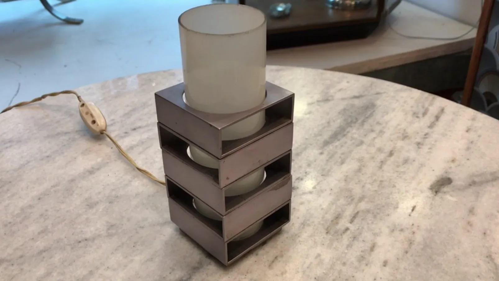 Luminária de mesa antiga de design moderno em uma superfície clara.