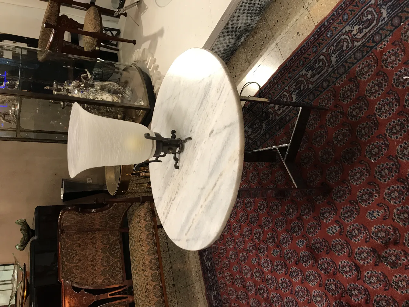 Antike Tischlampe im klassischen Design, vor einem dekorativen Hintergrund.