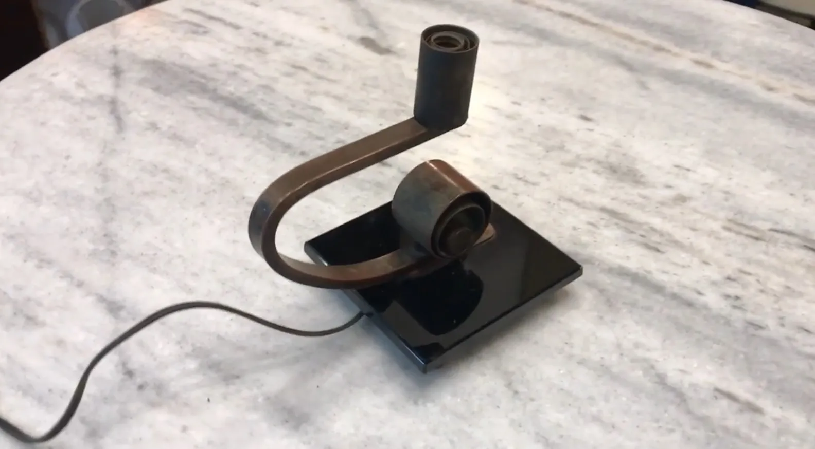 Lampe de bureau ancienne avec une base noire et des détails arrondis.