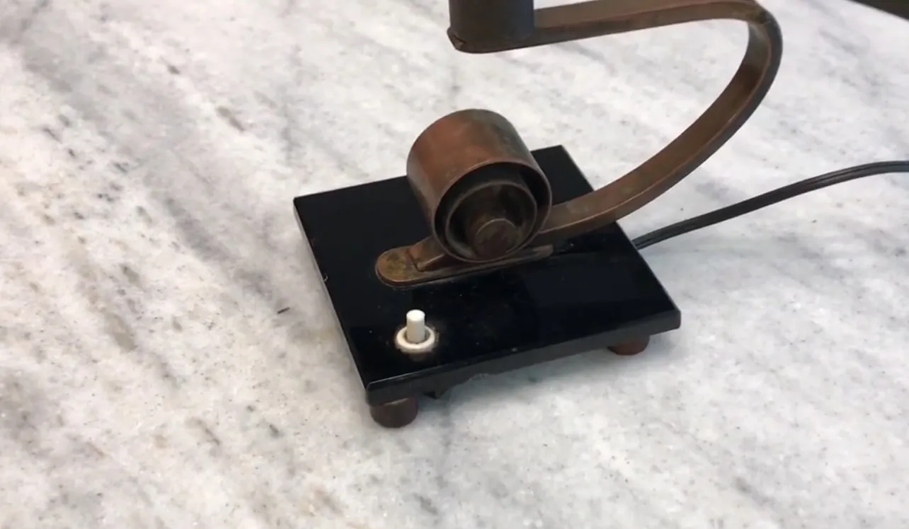 Antike Tischlampe mit schwarzem Sockel und metallischen Details, perfekt für die Dekoration.