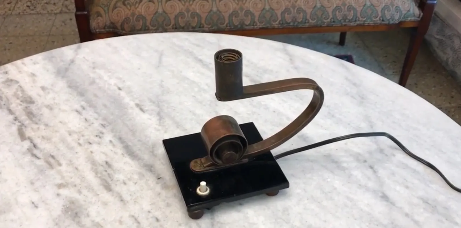 Antiga luminária de mesa com design único em uma mesa de mármore