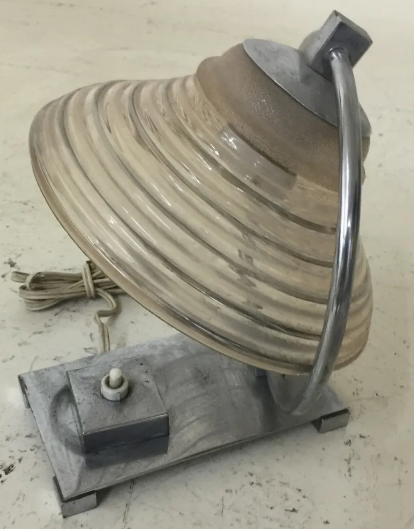 Antiga luminária de mesa com design curvado e base robusta.